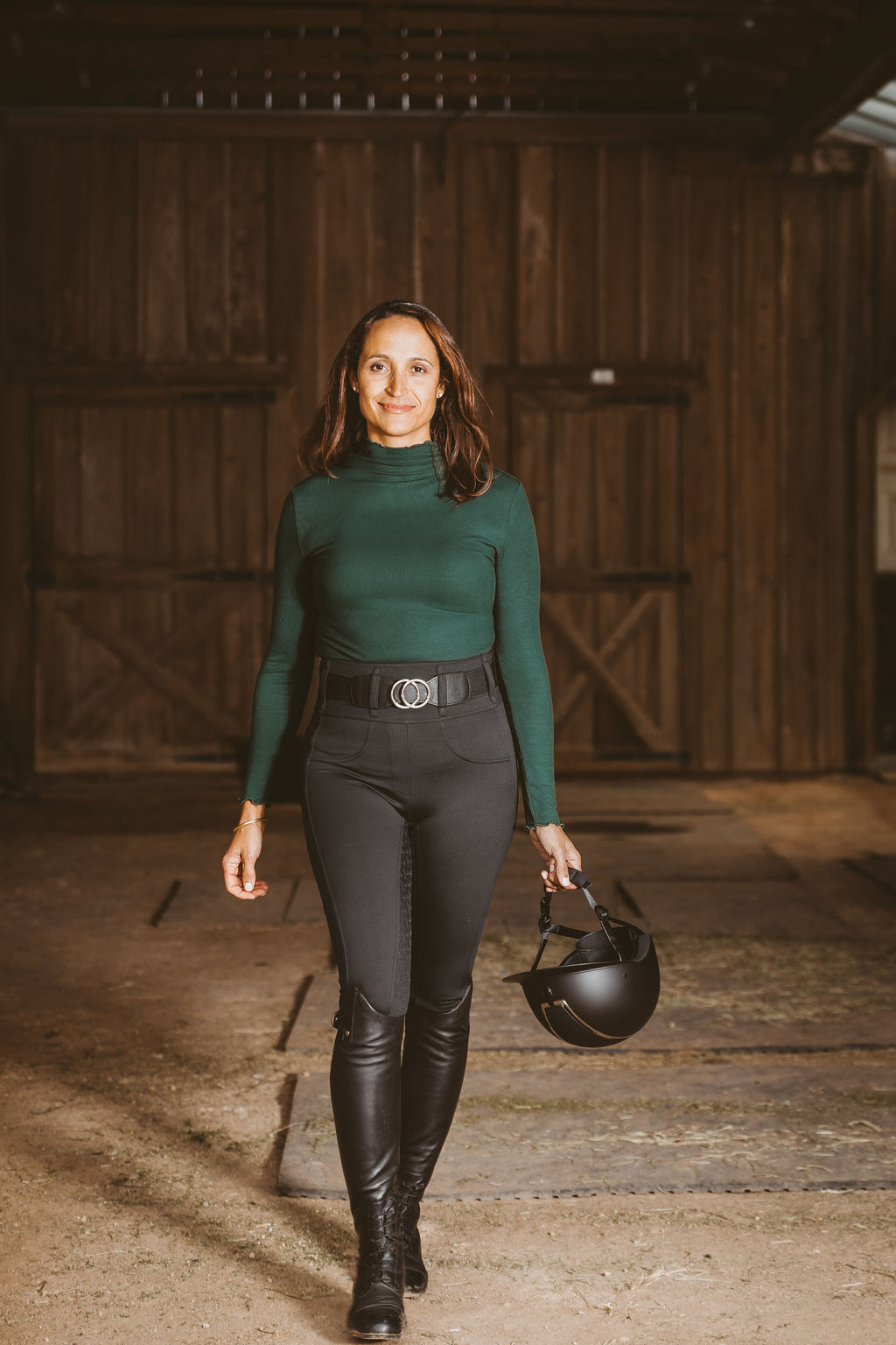 Equestrian woman wearing Canter Culture's black athletic breech featuring a high waist and faux front pockets.